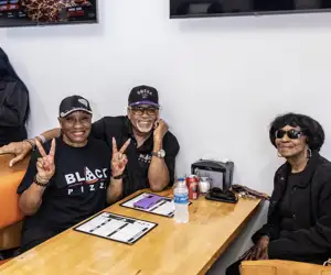 Happy guests enjoying a meal at Black Pizza. 