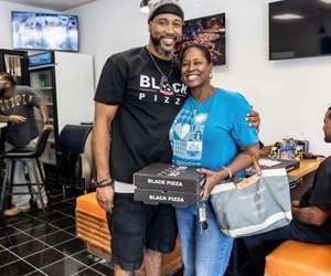 Business owner sharing Black Pizza with a guest in Atlanta. 