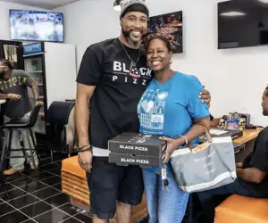 Business owner sharing Black Pizza with a guest in Atlanta. 