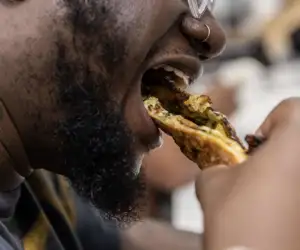 Guest enjoying a bite of delicious pizza at Black Pizza. 