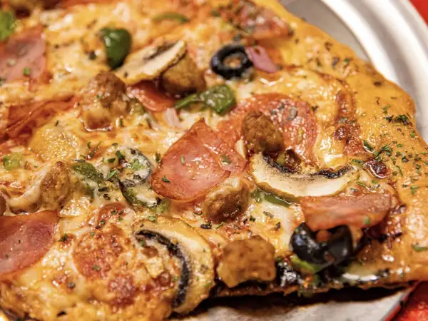 Delicious Black Pizza with olives, ham and peppers, serving Atlanta. 