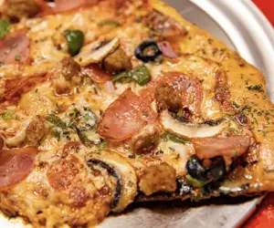Delicious Black Pizza with olives, ham and peppers, serving Atlanta. 